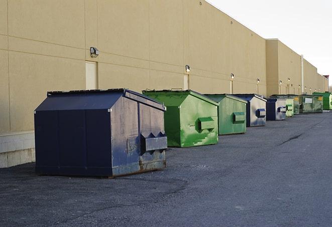 tilted front-load dumpsters being emptied by waste management workers in Aspen Hill MD